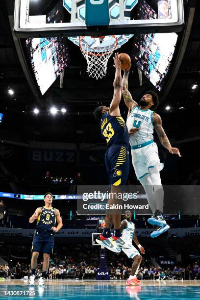 Myles Turner of the Indiana Pacers blocks a dunk attempt by Nick Richards of the Charlotte Hornets in the first quarter during a preseason game at...