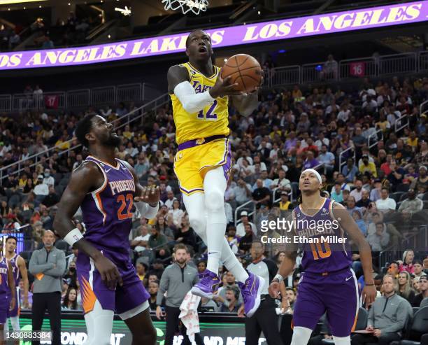 Kendrick Nunn of the Los Angeles Lakers drives to the basket against Deandre Ayton of the Phoenix Suns as Damion Lee of the Suns defends in the first...