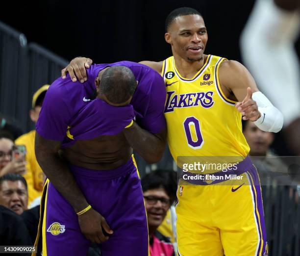 LeBron James and Russell Westbrook of the Los Angeles Lakers laugh on the sideline after Westbrook was called for a technical foul on the bench in...