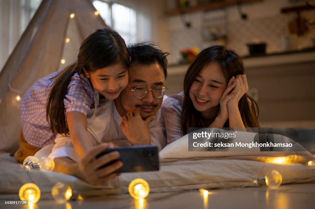 Parents and daughters enjoying the house. At night, make your own tent. and share your smartphone, take a selfie