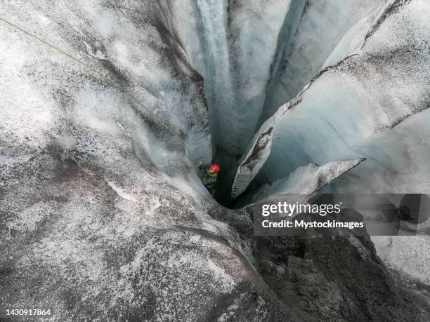 homme grimpant sur la glace à l’intérieur d’une crevasse glaciaire en islande - rope high rescue photos et images de collection