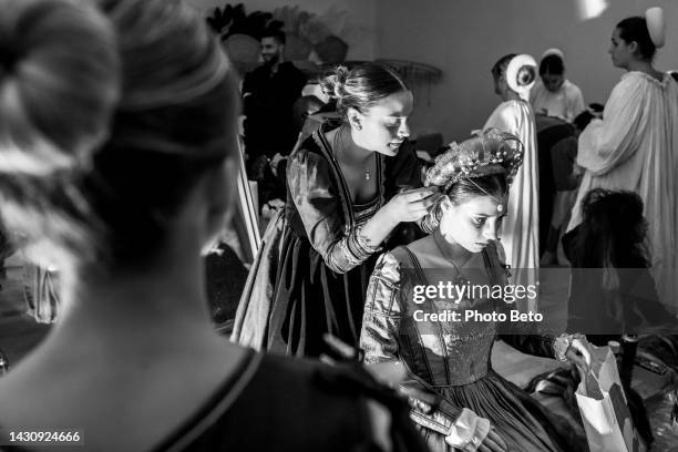 a woman prepares for the historical parade during the palio in the medieval town of gualdo tadino - period costume stock pictures, royalty-free photos & images