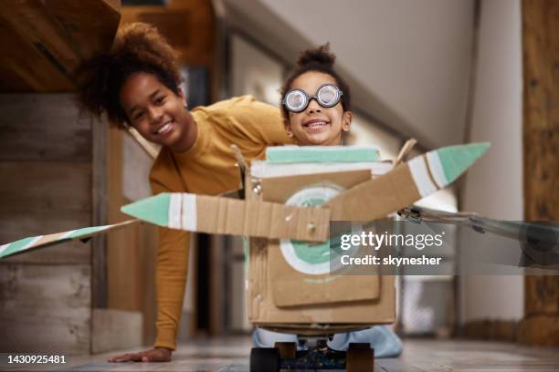 happy black girl pretending to be a pilot at home. - pretending to be a plane stockfoto's en -beelden