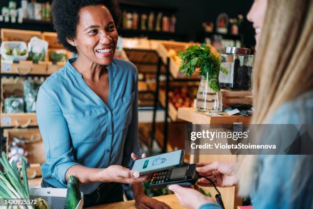 customer paying bill using a smartphone. - happy cashier stock pictures, royalty-free photos & images