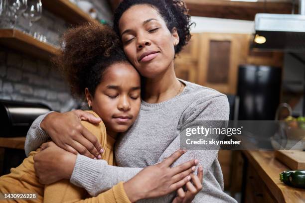 affectionate african american mother and daughter embracing at home. - sad mother stock pictures, royalty-free photos & images