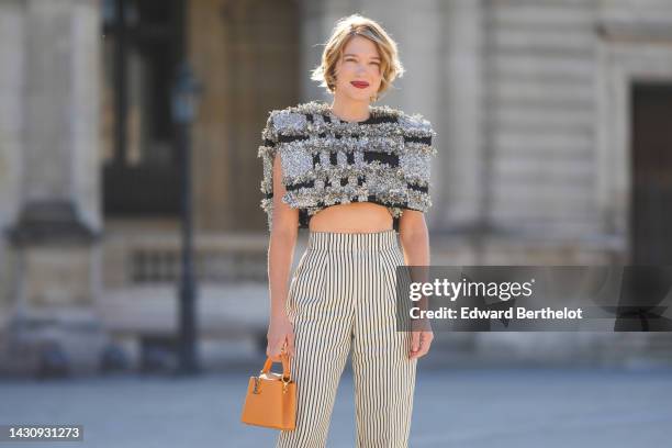 Lea Seydoux wears a black with embroidered silver fringed checkered pattern sleeveless / cropped top from Louis Vuitton, high waist white with black...