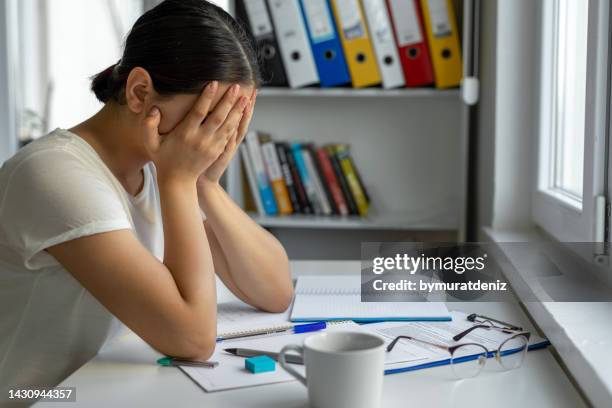 university student sadeness alone while sitting on table doing homework - struggle stock pictures, royalty-free photos & images