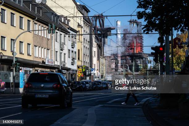 People cross a street as the ThyssenKrupp steel factory looms behind on October 06, 2022 in Duisburg, Germany. The German economy, and German...