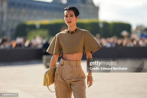 Molly Chiang wears gold earrings from Louis Vuitton, a brown LV monogram print pattern in coated canvas necklace from Louis Vuitton, a brown short...