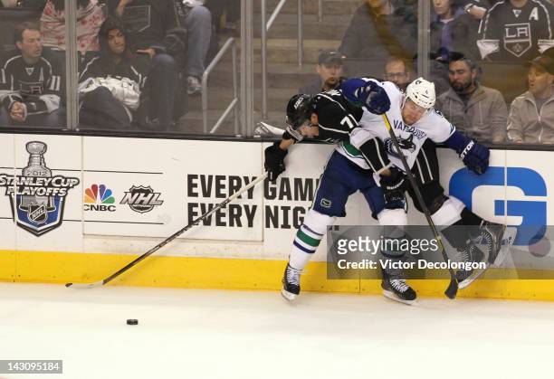 Keith Ballard of the Vancouver Canucks checks Jordan Nolan of the Los Angeles Kings in the third period in Game Four of the Western Conference...
