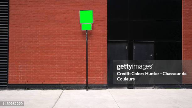 brown brick and black painted concrete wall with doors, pavement and empty road signs in montreal, qc, canada - hunter brown stock pictures, royalty-free photos & images