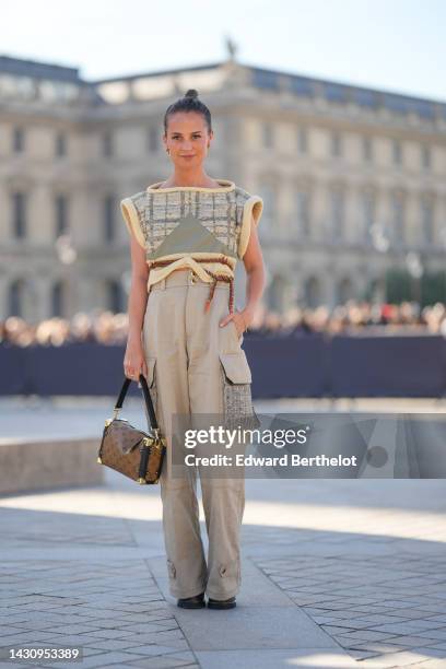 Alicia Vikander wears a pale yellow and green tweed checkered print pattern and yellow borders shoulder-pads / sleeveless cropped top from Louis...