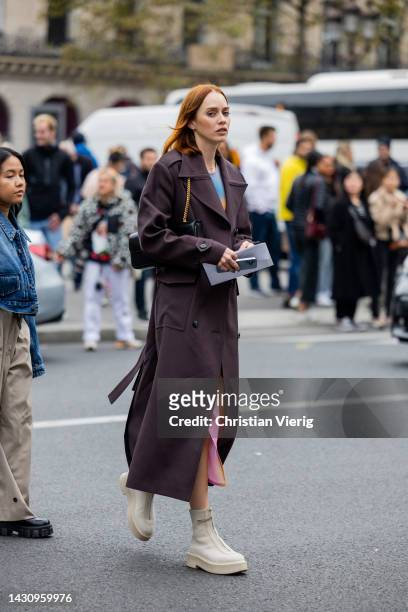 Guest wears double breasted coat, dress with batik print outside Thom Browne during Paris Fashion Week - Womenswear Spring/Summer 2023 : Day Eight on...