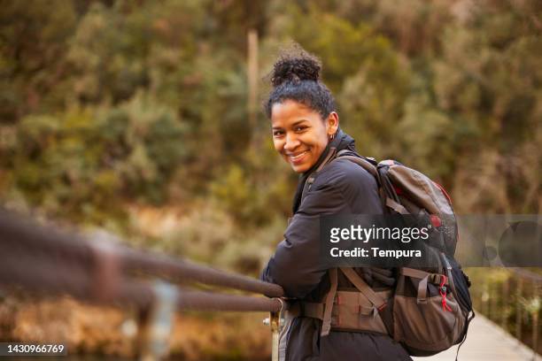 a beautiful smiling woman looks at the camera on a trekking trip. - mid adult women stock pictures, royalty-free photos & images