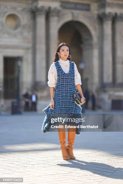 Yoyo Cao wears a white wool turtleneck / studded pullover from Louis Vuitton, a navy blue and blue checkered embroidered tweed tank-top asymmetric...