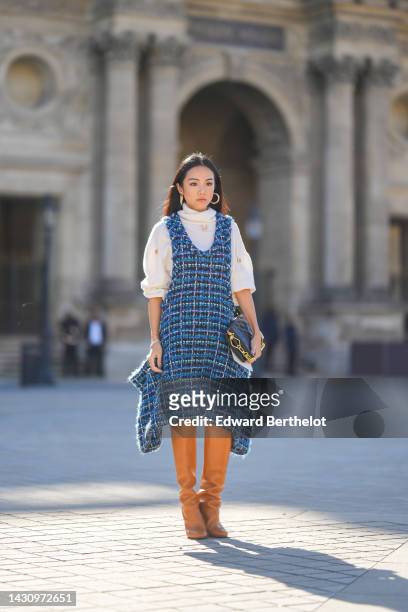 Yoyo Cao wears a white wool turtleneck / studded pullover from Louis Vuitton, a navy blue and blue checkered embroidered tweed tank-top asymmetric...