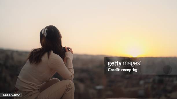 カッパドキア・テュルキエで自然の写真やビデオを撮っている若い女性観光客 - young woman standing against clear sky ストックフォトと画像