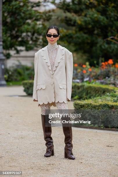 Aimee Song wears latte over sized blazer, laced pants, top, brown over knees boots outside Zimmermann during Paris Fashion Week - Womenswear...