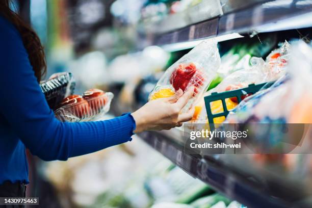 young asian woman shopping for fresh organic groceries in supermarket - taiwanese ethnicity stockfoto's en -beelden