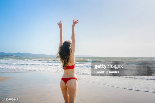 cheerful woman running towards the sea - wavy hair beach stock pictures, royalty-free photos & images