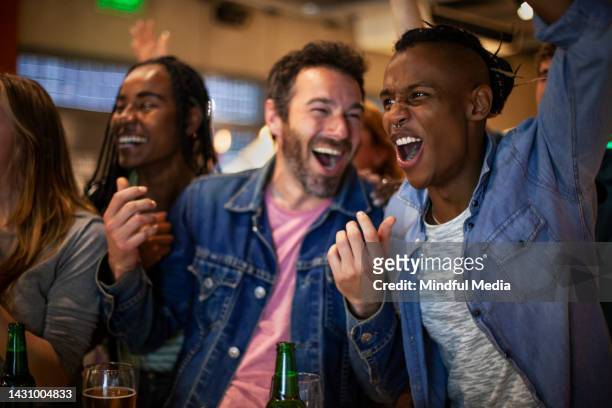 group of friends at crowded bar following presidential elections and celebrating candidate's victory - crowd cheering bar stock pictures, royalty-free photos & images