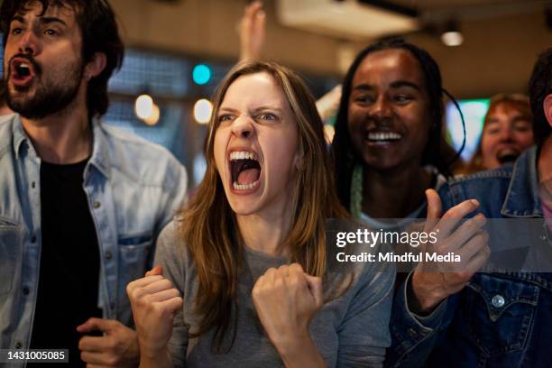 group of euphoric soccer fans at sports bar celebrating after team scores goal - chant stock pictures, royalty-free photos & images