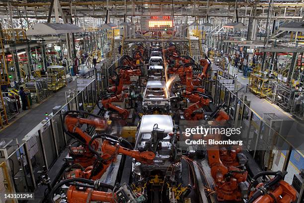 Robotic arms work on vehicles as they move along the production line at the Ford India Pvt. Maraimalai Nagar factory in Chengalpattu, India, on...