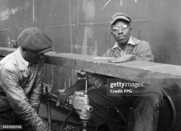 Two shipyard workers operating an pneumatic hole borer during construction of the USS Indiana, a South Dakota-class fast battleship, built by Newport...