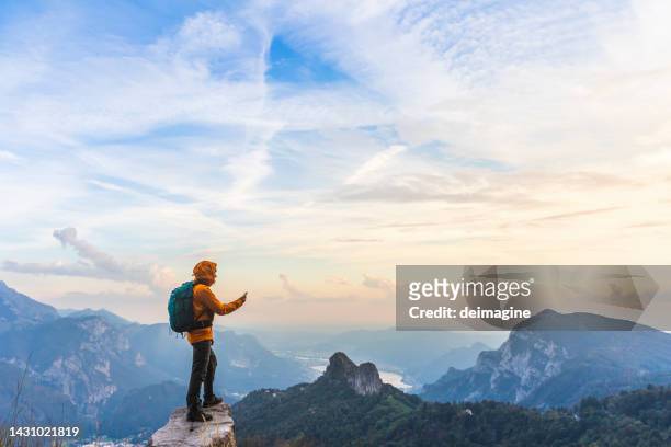 escursionista in cima alla montagna utilizzando l'app per smartphone - scienza e tecnologia foto e immagini stock