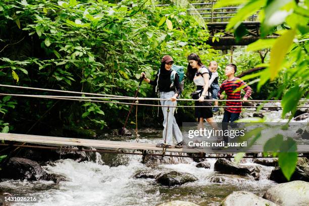 chinesische frau und muslimische freundin gehen gemeinsam auf der hängebrücke - wildnisgebiets name stock-fotos und bilder