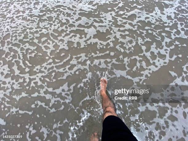 bare feet sea water - bare footprints stock-fotos und bilder