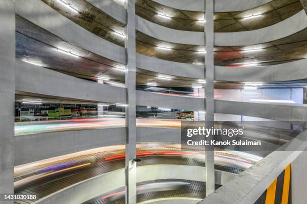 car driving down spiral parking garage ramp at night - leaves spiral stock pictures, royalty-free photos & images