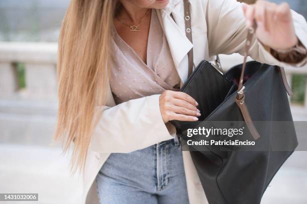 woman taking wallet out of her bag - purse stock pictures, royalty-free photos & images