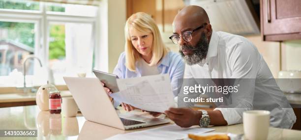 balancing the home finances - mature adult couples stock pictures, royalty-free photos & images