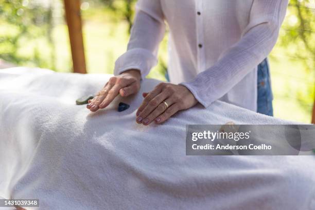mujer en sesión de reiki con mujer de mediana edad - reiki fotografías e imágenes de stock