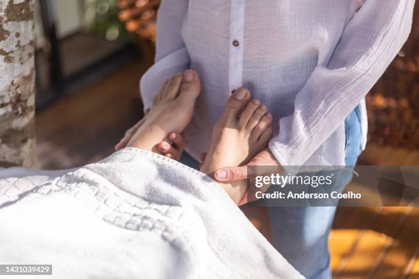 reiki therapist with but hands on a woman's feet - energy healing stock pictures, royalty-free photos & images