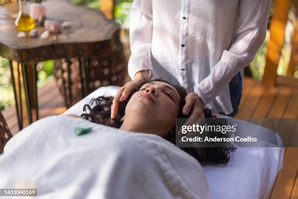 terapeuta colocando las manos sobre la mujer - reiki fotografías e imágenes de stock