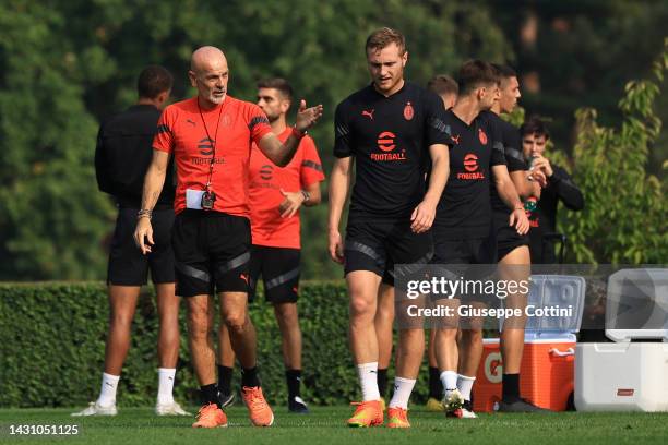 Stefano Pioli Head coach of AC Milan speaks with Tommaso Pobega during an AC Milan training session at Milanello on October 06, 2022 in Milan, Italy.