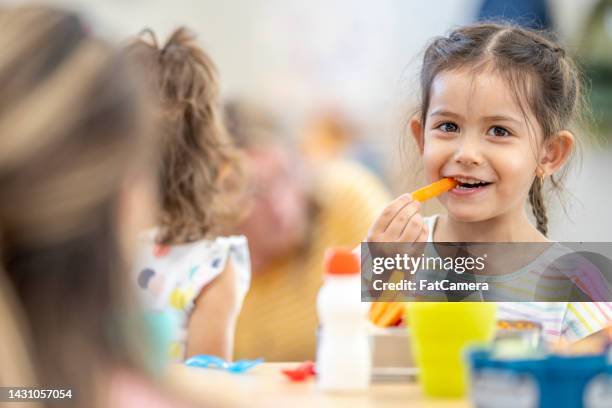 daycare children eating lunch - consume stockfoto's en -beelden