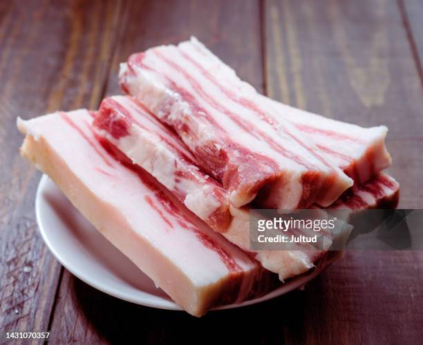 iberian bacon cut into strips on rustic wooden board - raw bacon stockfoto's en -beelden