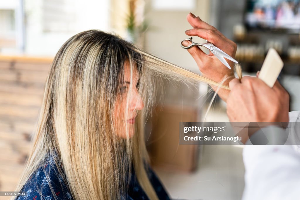 Giovane donna che ottiene un taglio di capelli dal parrucchiere
