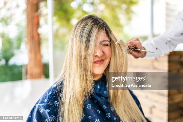young woman getting a haircut at the hairdresser - cutting long hair stock pictures, royalty-free photos & images