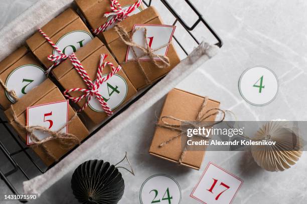 metal basket with craft paper boxes with numbers for children - christmas still life stock-fotos und bilder