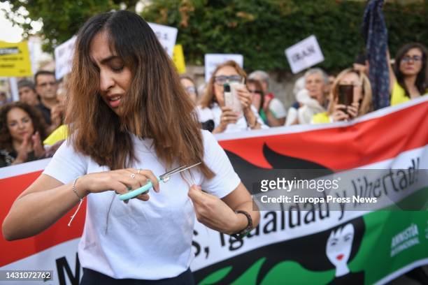 Woman cuts her hair at a rally against the death of two Iranian women, in front of the Iranian embassy, October 6 in Madrid, Spain. The rally was...