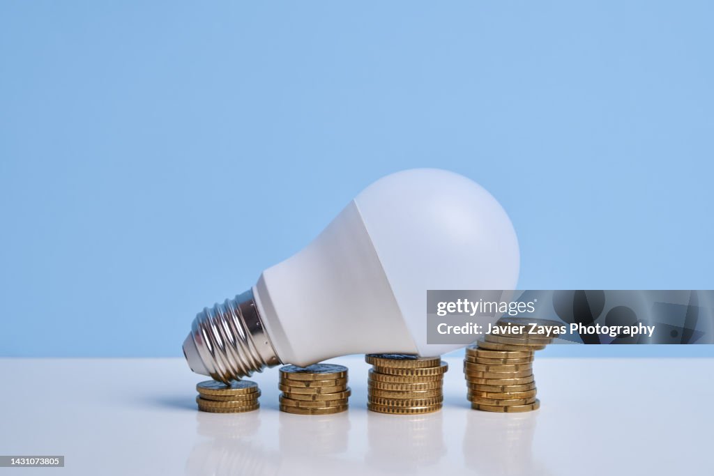 Light Bulb On Stacked Coins Simulating Financial Growth Graph