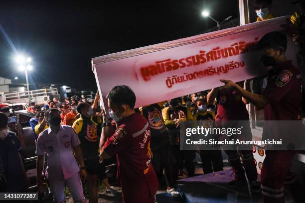 Emergency workers carry coffins containing the bodies of victims on October 06, 2022 at a hospital in Udon Thani, Thailand. Thai police said that...