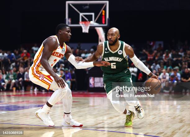 Jevon Carter of Milwaukee Bucks handles the ball against Aaron Holiday#3 of Atlanta Hawks during a preseason NBA game between Atlanta Hawks and...