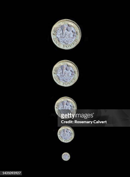 shrinking pound illustrated by reduced coin size, on black. - encoger fotografías e imágenes de stock