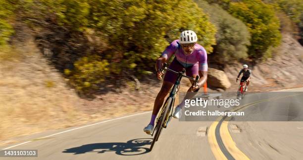 african-american  cyclist leading peloton on a bike ride - spandex stockfoto's en -beelden