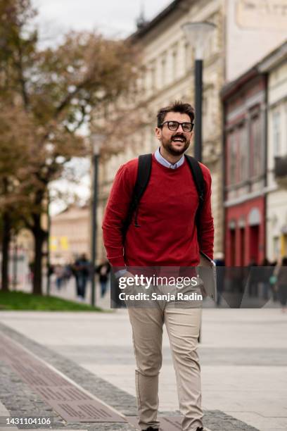 handsome young man walking to work - homens de idade mediana imagens e fotografias de stock
